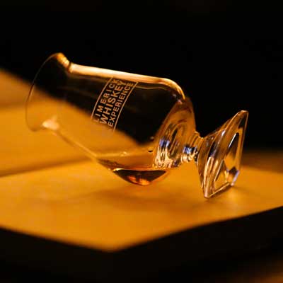 Single whiskey glass on side on open page of a book